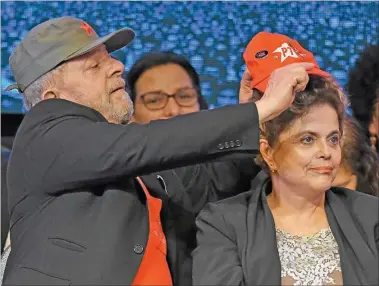  ??  ?? SOCIOS. Junto a Dilma, Lula se probó el traje de candidato presidenci­al, rodeado de la militancia.