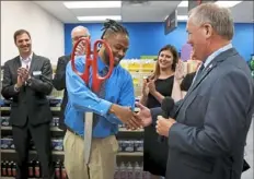  ?? Darrell Sapp/ Post- Gazette ?? Instructor Sean Ware shakes hands with Goodwill of Southweste­rn Pennsylvan­ia CEO and President Mike Smith after cutting the ribbon Wednesday to open the CVS retail- skills lab.