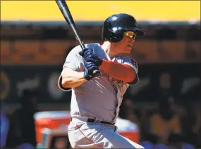  ?? Jason O. Watson / Getty Images ?? Boston’s Brock Holt hits an RBI double against Oakland during the seventh inning on Sunday.