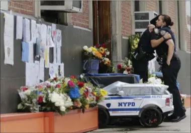  ?? SETH WENIG — THE ASSOCIATED PRESS ?? Police officers hug in front of the 46th Precinct in the Bronx borough of New York Thursday Police officer Miosotis Familia, who worked out of the 46th Precinct, was shot to death the day before, ambushed inside her command post RV by an ex-convict who...
