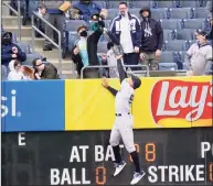  ?? Frank Franklin II / Associated Press ?? A fan catches a ball hit by Tampa Bay Rays’ Francisco Mejia for a home run as New York Yankees right fielder Aaron Judge (99) leaps at the wall during the second inning on Saturday.