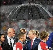  ?? MATTHIAS HANGST/GETTY IMAGES ?? FIFA President Gianni Infantino and President of Russia Vladimir Putin look on while Croatia players receive their second-place medals following the World Cup final against France on Sunday in Moscow. France won the game 4-2.