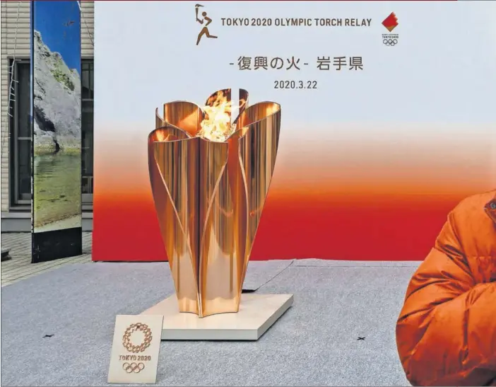  ??  ?? La llama olímpica aguarda en Japón a iniciar el tramo del relevo por el país, que comenzará el jueves 26 desde Fukushima. Un aficionado se hace una foto con ella.