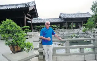  ??  ?? Steve Whysall stands with penjing plants in the Nan Lian Garden in Kowloon. Penjing, sometimes called tray scenery, features plants skilfully groomed in trays to create landscape art.