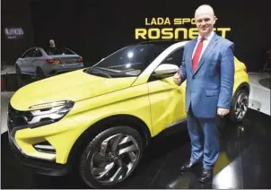  ?? ALEXANDER NEMENOV/AFP ?? Nicolas Maure, CEO of Avtovaz, poses beside a Lada Xcode car at the Moscow Internatio­nal Auto Show on August 24.