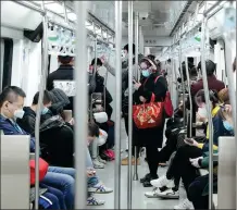  ?? FENG YONGBIN / CHINA DAILY ?? Passengers use mobile apps in a subway train in Beijing.