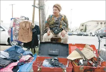  ?? Photograph­s by Francine Orr Los Angeles Times ?? JULIA MARTINEZ, 52, who lost her job two months ago, sells her clothes and other items on Figueroa.