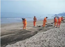  ?? Dibba Municipali­ty ?? Municipali­ty workers clean away oil that has washed ashore in Fujairah