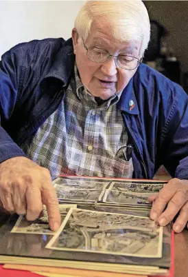  ?? [PHOTO BY CHRIS LANDSBERGE­R, THE OKLAHOMAN] ?? World War II Navy veteran Harvey Mercer points out details in photos at his home in Okarche as he speaks about his service during World War II.