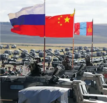  ?? SERGEI GRITS) / THE ASSOCIATED PRESS ?? Russian, Chinese and Mongolian national flags set on armoured vehicles during the Vostok military training exercises in Eastern Siberia on Thursday.