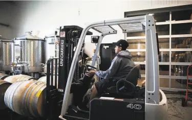  ?? Talia Herman / Special to The Chronicle ?? Christian Ortiz moves barrels at Grand Cru Custom Crush, which makes wine for about 20 brands.