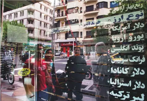  ?? Bloomberg ?? Above: Residents stand outside a closed currency exchange in Tehran.