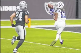  ?? Erik Verduzco Las Vegas Review-journal @Erik_verduzco ?? Indianapol­is Colts wide receiver T.Y. Hilton catches a touchdown pass while being pursued by Las Vegas Raiders safety Johnathan Abram on Dec. 13.