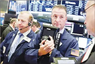  ?? (AP) ?? Traders James Dougherty, Jonathan Corpina and Neil Catania (left to right), work on the floor of the New York Stock Exchange on June 13. Technology stocks are leading the market slightly higher in early trading, making up
some of the ground they lost...