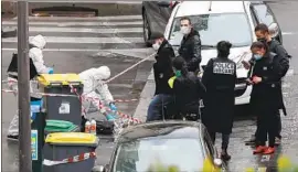  ?? Thibault Camus Associated Press ?? POLICE gather Friday in the area of a knife attack that wounded two journalist­s near the former off ices of satirical magazine Charlie Hebdo in Paris.