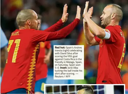  ?? — Reuters / AFP ?? Red hot: Spain’s Andres Iniesta (right) celebratin­g with David Silva after scoring the fifth goal against Costa Rica in the friendly in Malaga, Spain, on Saturday. Spain won 5- 0. Inset: Jordi Alba tucking the ball inside his shirt after scoring.