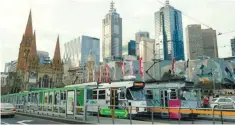  ??  ?? Trams pass by Melbourne’s skyline in Australia’s second-largest city.