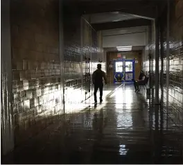  ?? PHOTOS BY CHARLIE RIEDEL — THE ASSOCIATED PRESS ?? A student walks between classes at Wyandotte High School in Kansas City, Kan., on Wednesday.