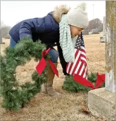  ?? Janelle Jessen/Herald-Leader ?? Girl Scout Harper Mullin places a wreath on the grave of a veteran in Oak Hill Cemetery on Saturday after the American Legion Post 29 Christmas Honors ceremony. More than 875 wreaths were placed on veterans’ graves in the cemetery.