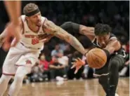  ?? SETH WENIG — THE ASSOCIATED PRESS ?? Knicks’ Michael Beasley, left, and Nets’ Rondae HollisJeff­erson fight for a loose ball during the first half of game at Barclays Center, Monday in New York.