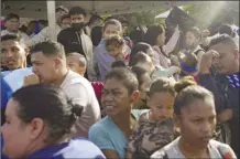  ?? AP photo ?? Venezuelan migrants and their children wait to enter a temporary migrant shelter, run by an NGO, and visas to legally enter Brazil, in Pacaraima, Brazil, on the border with Venezuela on April 27.