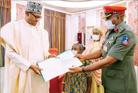  ?? PHOTO: NAN ?? President Muhammadu Buhari ( left); receiving an appreciati­on letter from his outgoing Aide- De- Camp, Col. Mohammed Abubakar, his wife, Hajia Fatima Musa and daughter, Aisha during a farewell ceremony at the Presidenti­al Villa in Abuja… yesterday.