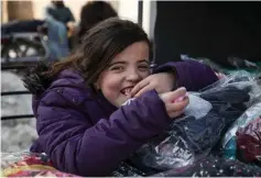  ??  ?? A Syrian girl eats candy floss in the town of Darret Ezza in the northern Syrian Aleppo province close to the Turkish border. — AFP photo