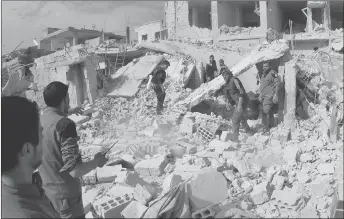  ?? SYRIAN CIVIL DEFENSE WHITE HELMETS VIA AP ?? Civil defence workers and civilians inspect a damaged building after airstrikes hit a rebel-held suburb near Damascus, Syria.