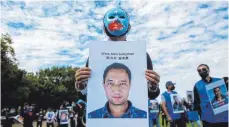  ?? FOTO: AZIZ SULAYMAN/DPA ?? Ein Demonstran­t hält bei einem Protest von Uiguren in Washington ein Bild von Alim Sulayman in der Hand.