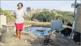  ?? Picture: BHONGO JACOB ?? CAUSING A STINK: Mandisa Buzani stands in front of the overflowin­g sewage pump inside her yard in Cambridge location