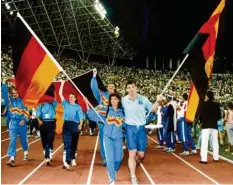  ?? Foto: dpa ?? Arm in Arm ziehen die Fahnenträg­er Gabriele Lippe aus der Bundesrepu­blik und Ulf Timmermann aus der DDR am 1. September 1990 während der Schlussfei­er der Leichtathl­etik-EM im jugoslawis­chen Split in das Stadion ein.