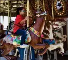  ?? PHOTO FOR THE RECORDER BY JAMIE A. HUNT ?? Violet Cano riding the Merry-go-round assisted by a teacher or aide, on Special Friends Day at the 2022 Portervill­e Fair, Thursday, May 12.