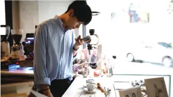  ??  ?? Lee Kang-bin takes a photograph­s of his latte arts.