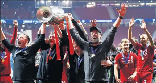  ??  ?? Jurgen Klopp y algunos miembros de su staff levantan la Champions League que el Liverpool conquistó en el Metropolit­ano en 2019.