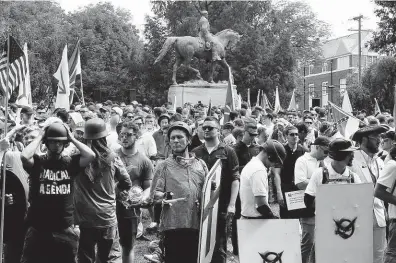  ?? Bílí nacionalis­té pod sochou jižanského generála Leeho v Charlottes­ville (12. srpna). FOTO REUTERS ?? Ochrana monumentů jako záminka.