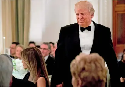  ?? AP ?? President Trump walks towards first lady Melania Trump after speaking at a dinner reception for the governors during the annual National Governors Associatio­n winter meeting, at the State Dining Room of the White House in Washington. —