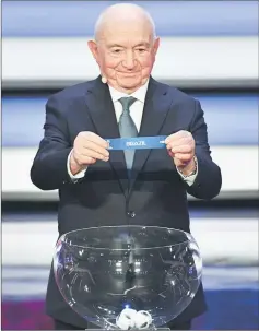  ??  ?? Former USSR forward and coach Nikita Simonyan displays the slip of Brazil during the final draw for the 2018 FIFA World Cup at the State Kremlin Palace in Moscow. — AFP photo