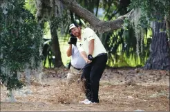  ?? Associated Press photo ?? J.B. Holmes hits from under a tree near the second fairway during the third round of The Players Championsh­ip golf tournament, Saturday, in Ponte Vedra Beach, Fla.