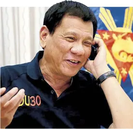  ??  ?? GOOD RAPPORT: President Duterte is all smiles as he talks to US president-elect Donald Trump on the phone at the Legaspi Suites in Davao City the other night. During the seven-minute phone conversati­on, Trump told Duterte the Philippine­s was conducting...