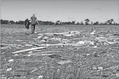  ?? [SARAH A. MILLER/TYLER (TEXAS) MORNING TELEGRAPH] ?? Kyle Allen walks among shattered buildings on his parents’ property in Canton, Texas, on Sunday. He was looking for personal items after tornadoes hit the area on Saturday night. Severe storms, including tornadoes, swept through several small towns in...