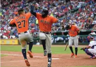  ?? Associated Press ?? ■ Houston Astros' Jose Altuve (27) and Carlos Correa (1) celebrate Correa's home run with scored Altuve in the seventh inning of a baseball game Saturday in Arlington, Texas.