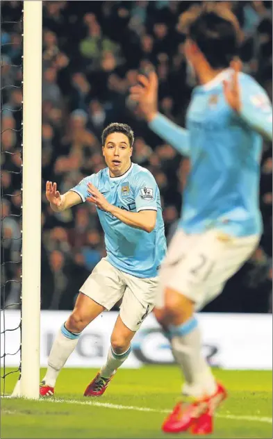  ??  ?? n Samir Nasri wheels away in delight after scoring City’s second goal to make the game safe.