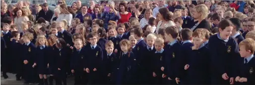  ??  ?? Some of the students waiting for the big opening and above, Fr Hickey and Anne Phillips, Deputy Principal, perform the official opening at Scoil Naomh Buithe.