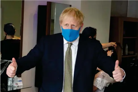 ??  ?? Boris Johnson wears a face mask during a visit to a hair salon in his Uxbridge constituen­cy yesterday