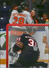  ?? NEWS PHOTO RYAN MCCRACKEN ?? Medicine Hat Tigers forward Elijah Brown celebrates with teammate Ryan Chyzowski after scoring a goal on Calgary Hitmen goaltender Jack McNaughton during a Western Hockey League game at Canalta Centre Friday.