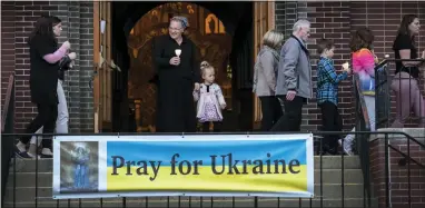  ?? AP PHOTOS/WONG MAYE-E ?? Parishione­rs walk in procession around the church Friday during a Good Friday service at St. Mary’s Ukrainian Orthodox Cathedral in Allentown, Pa.