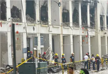  ?? SUNSTAR FOTO / AMPER CAMPAÑA ?? PROBE. Fire investigat­ors leave the damaged building of Metro Ayala Center Mall on Monday morning, a few hours before “fire out” was declared before 5 p.m.