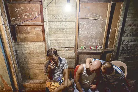  ??  ?? “Barker na tulak ng droga, wag tularan.” Family and friends of Rey Carlo Isles mourn during his wake on December 1, 2016. Isles, 22, was found dead in Brgy. San Isidro, Makati City, with his head wrapped in plastic and packaging tape and his hands...