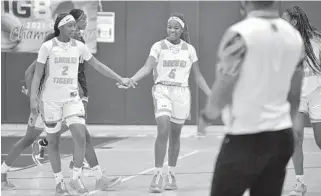  ?? MICHAEL LAUGHLIN/SUN SENTINEL ?? Ely’s Janessa Kelley, center, smiles after hitting the game-winning shot against St. Thomas Aquinas in their Big 8 finals game on Saturday at South Plantation High. The Tigers beat the Raiders in the Big 8 finals for the second year in a row.