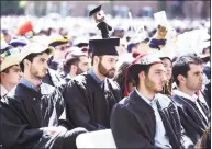  ??  ?? Above, Andrew Moran, center, of Branford College wears a hat decorated with a doll in his likeness for Class Day at Yale University in New Haven on Sunday.